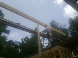Carpenter setting a ridge beam over a new addition frame — Ice Dam Removal by Roofing Brothers in Evansville