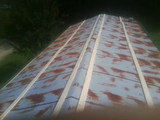 Rusted metal roof panels with new wood purlins before replacement — Storm Damage Roof Repair in Evansville by Roofing Brothers