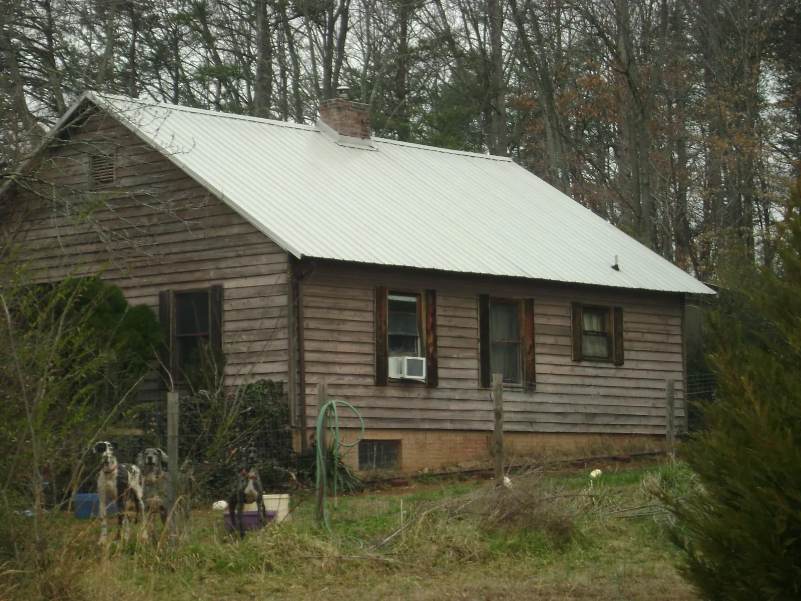 White metal roof on an old wood sided farmhouse, from a Metal Roof Installation job in Evansville